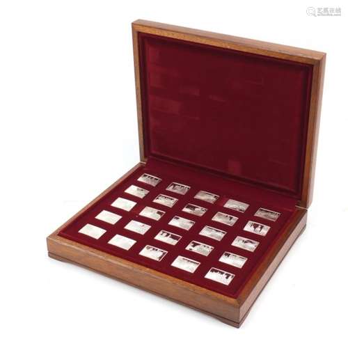 Twenty five silver commemorative ingots by John Pinches arranged in a fitted display case, each