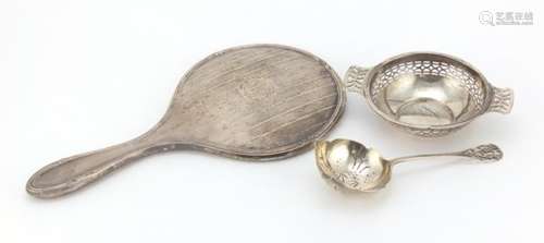 Silver items comprising a hand mirror, twin handled bonbon dish and a sifting spoon, various