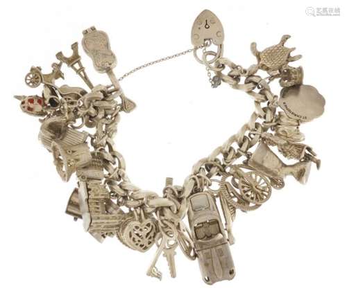 Silver charm bracelet with large selection of silver charms including windmill, church, toaster