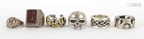 Six silver and white metal rings including a intaglio lion seal and a skull, various sizes, 80.