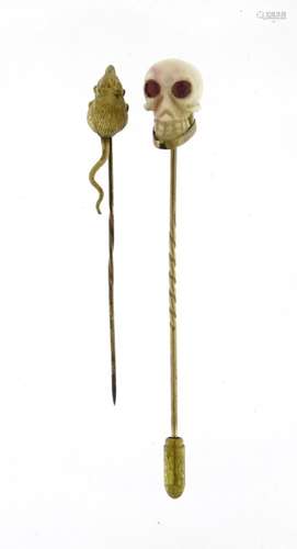 Two gold coloured metal tie pins comprising a mouse and carved coral skull with ruby eyes, the