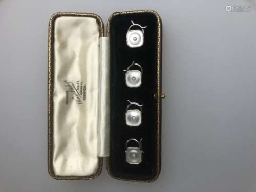 A cased set of four yellow and white metal diamond set mother-of-pearl studs