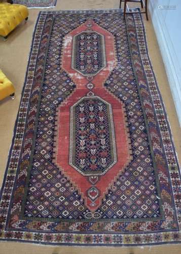 An antique Caucasian kelleh carpet, the large twin lozenge design on blue/red ground