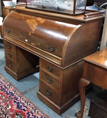 An antique walnut cylinder top kneehole desk