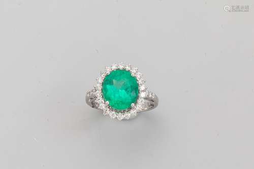 18k white gold ring set with an oval cut emerald o…