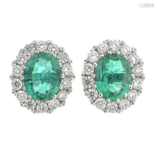 A pair of 18ct gold emerald and diamond cluster