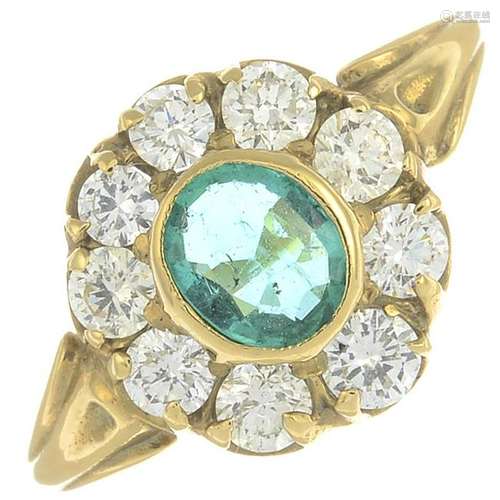 An emerald and diamond cluster ring.Emerald calculated