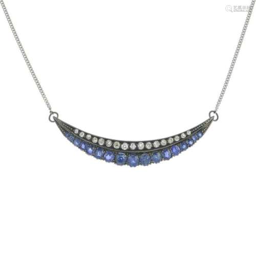 A sapphire and diamond crescent pendant, suspended from