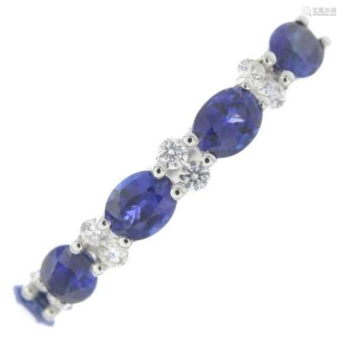 A sapphire and diamond half eternity ring.Sapphire