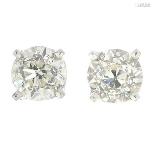 A pair of vari-cut diamond single-stone stud earrings.