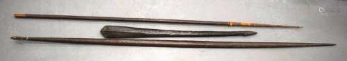 TWO TRIBAL SPEARS AND A PADDLE. 200 cm long. (3)
