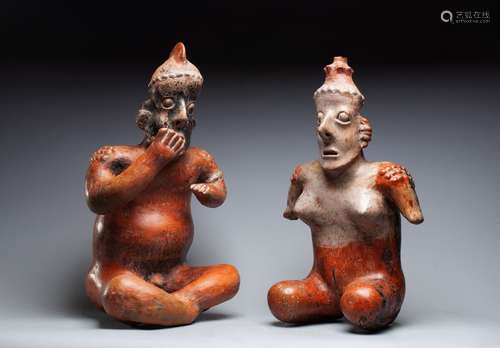 Couple de statuettes, présenté assis et nu. Leurs