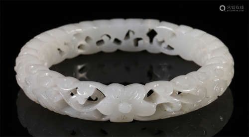 A CHINESE CARVED JADE FLOWER BANGLE