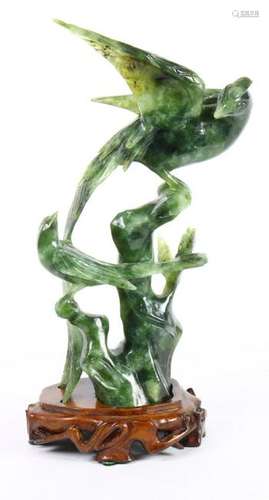 Two carved spinach jade birds on wooden stand, one is