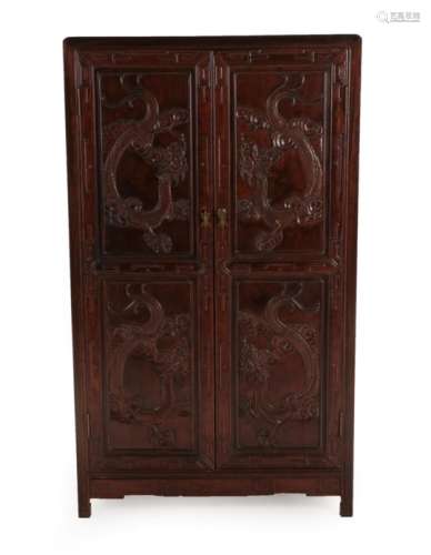 A Chinese Hardwood Cupboard, 20th century, the two twin-panelled doors carved with dragons enclosing