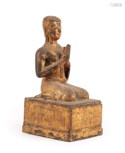 A Gilt Metal Figure of Buddha, Thai, 19th century, the kneeling figure with hands at prayer, on a