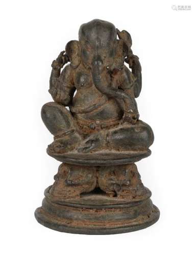 An Indian Bronze Figure of Ganesha, probably 10th century, seated on a circular plinth supported