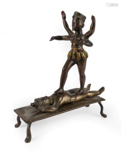 An Indian Cold Painted and Gilt Figure Group, 19th century, modelled as Kali walking on Shiva, on