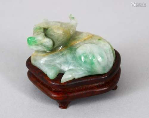 A 19TH / 20TH CENTURY CHINESE CARVED JADEITE FIGURE OF A BULL, the bull in a recumbent position,