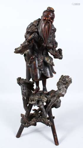 A LARGE 19TH CENTURY CHINESE ROOTWOOD CARVING OF SHOU LAO, stood upon a naturalistic form base,