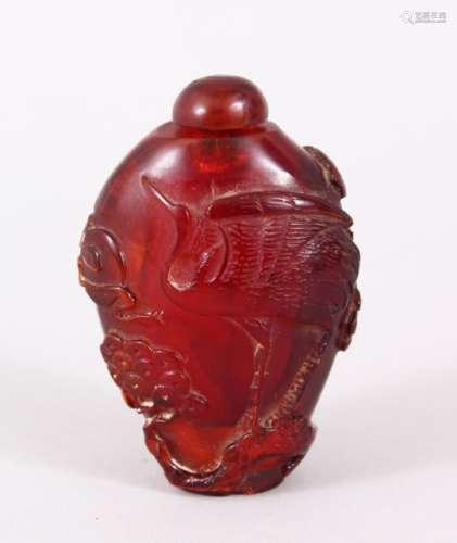 A GOOD QIANLONG CHINESE CARVED AMBER SNUFF BOTTLE, decorated with scenes of cranes amongst pine