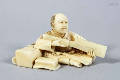 A JAPANESE MEIJI PERIOD CARVED IVORY OKIMONO OF AN ARTISAN, in a seated position working with his