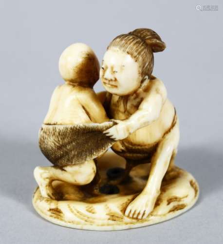 A GOOD JAPANESE MEIJI PERIOD CARVED IVORY NETSUKE OF TWO WRESTLERS, the two wrestlers captured mid