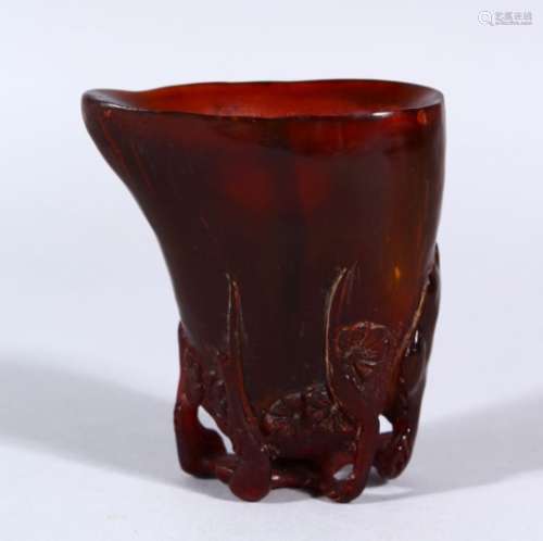 A SMALL CHINESE HORN LIBATION CUP, carved with lower sprays of cherry blossom, 8cm high