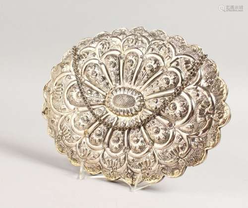 A GOOD CHINESE WHITE METAL MIRROR, of shaped oval outline, embossed with flowers and scrollwork,