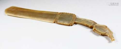 A 19TH CENTURY INDIAN PAGE TURNER, possibly rhino horn, with carved handle, 40cm long.