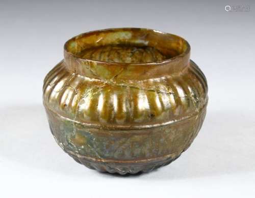 AN EARLY ISLAMIC MOULDED GLASS BOWL, decorated with a band of calligraphy, 11cm diameter.