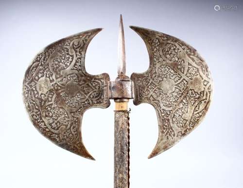 A GOOD QAJAR ENGRAVED STEEL DOUBLE-SIDED AXE, 52cm long, diameter of axe 28cm.