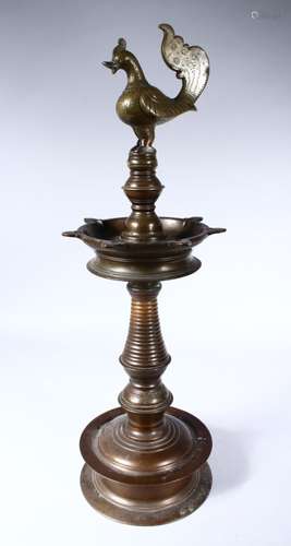 A GOOD 19TH CENTURY INDIAN BRONZE LAMP, with cockerel finial on a circular base, 60cm high.