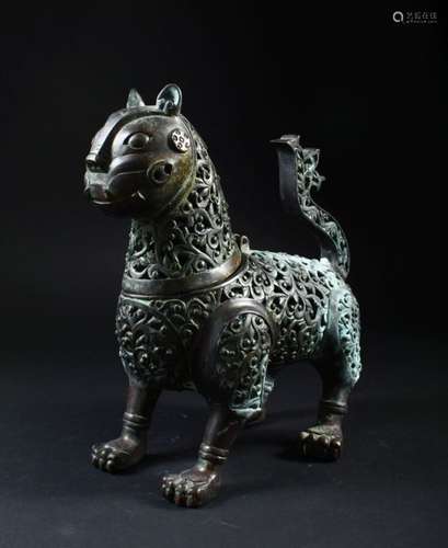 A GOOD PIERCED BRONZE INCENSE BURNER, modelled as a standing stylised lion, 27cm long.