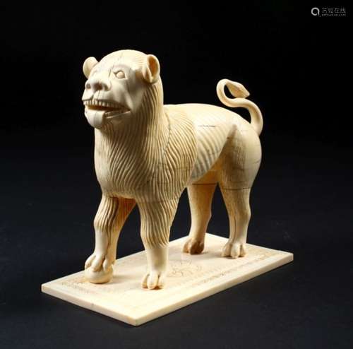 A GOOD EARLY CARVED IVORY MODEL OF A STANDING MALE LION, on a rectangular base, 13cm long.