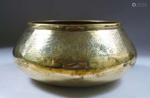 A 14TH CENTURY PERSIAN FARS BRASS BOWL, with calligraphic decoration, 11cm high x 23cm diameter.