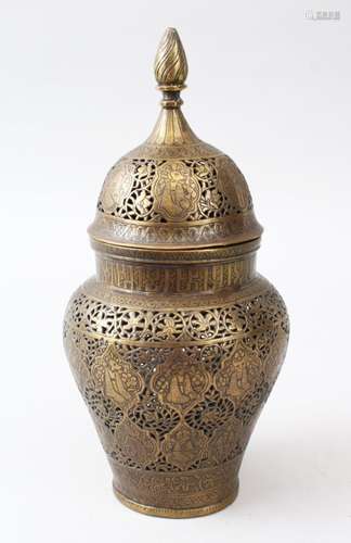 A 19TH CENTURY PERSIAN QAJAR ISLAMIC BRASS JAR AND COVER, with pierced and engraved decoration, 25cm