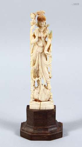 A 19TH CENTURY INDIAN CARVED IVORY FIGURE OF DEITY / BUDDHA, fitted to a hardwood base, 19cm high.