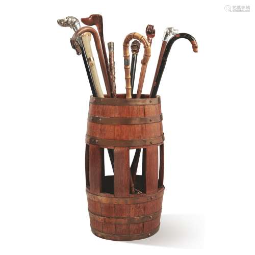 A BARREL-FORM OAK UMBRELLA STAND TOGETHER WITH A SELECTION OF TEN WALKING STICKS
