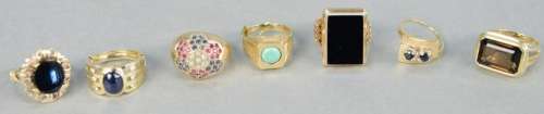 Six gold rings with stones, one with blue stone and