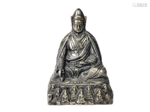 A TIBETAN/CHINESE WHITE METAL FIGURE OF A SEATED BUDDHA