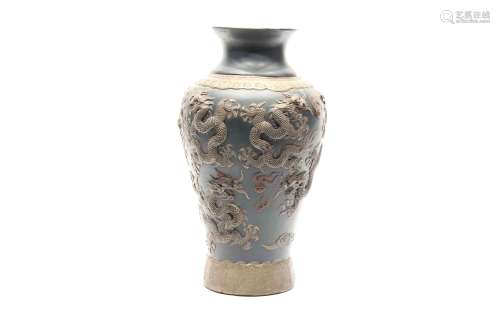Jarrón de cerámica china con dragones en relieve y fondo azul.
