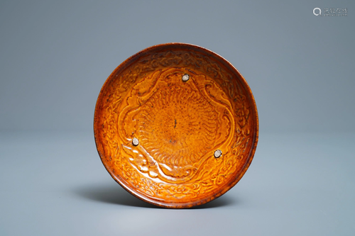 A Chinese amber-glazed relief-decorated saucer dish,