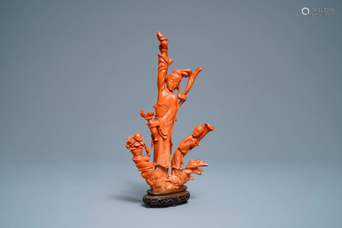 A Chinese carved red coral group of a lady and c…