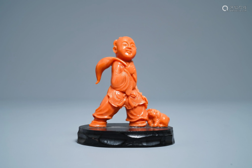 A Chinese carved red coral group of a boy with a…
