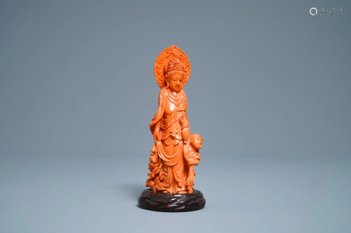A Chinese carved red coral group of Guanyin with…