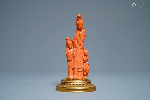 A Chinese carved red coral group of a lady and a…
