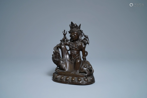 A Chinese silver-inlaid bronze figure of Guanyin on a
