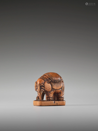 A WOOD NETSUKE OF A CAPARISONED ELEPHANT …