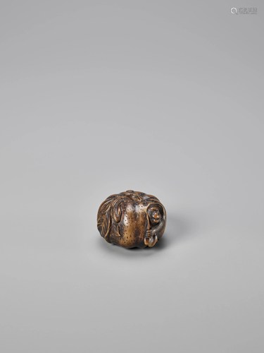 A WOODEN NETSUKE OF A MONKEY STUCK IN A …